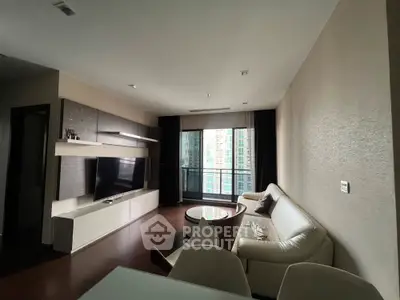 Modern living room with sleek furniture and large window offering city view