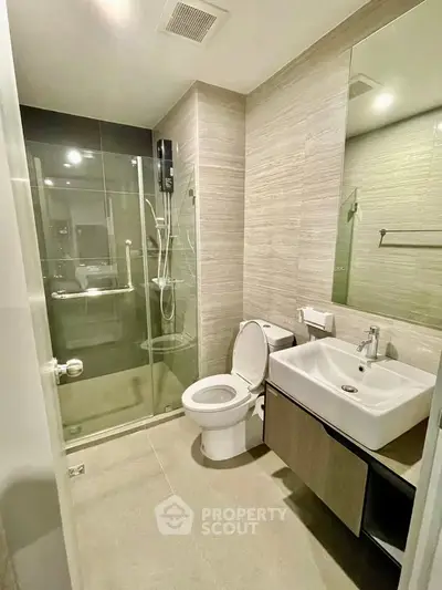Modern bathroom with glass shower and sleek fixtures in a contemporary apartment.