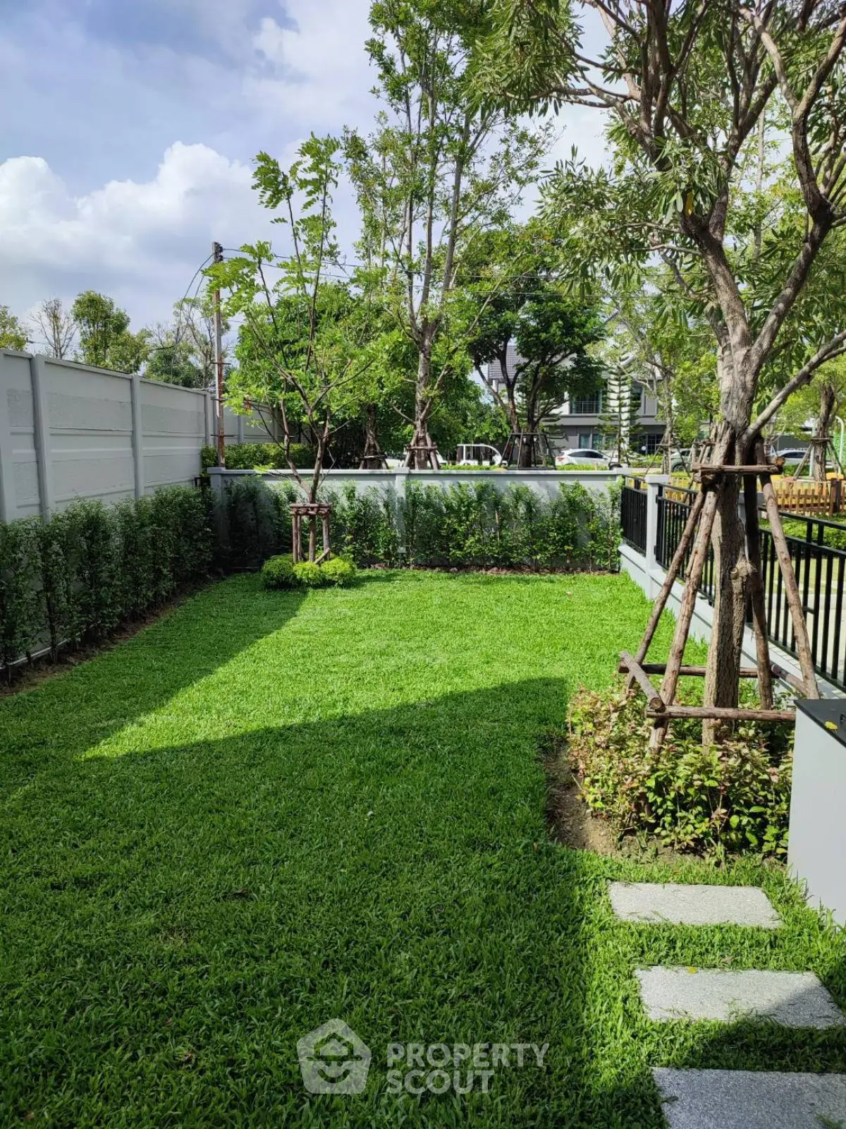 Spacious green garden with lush grass and trees, perfect for outdoor relaxation and activities.