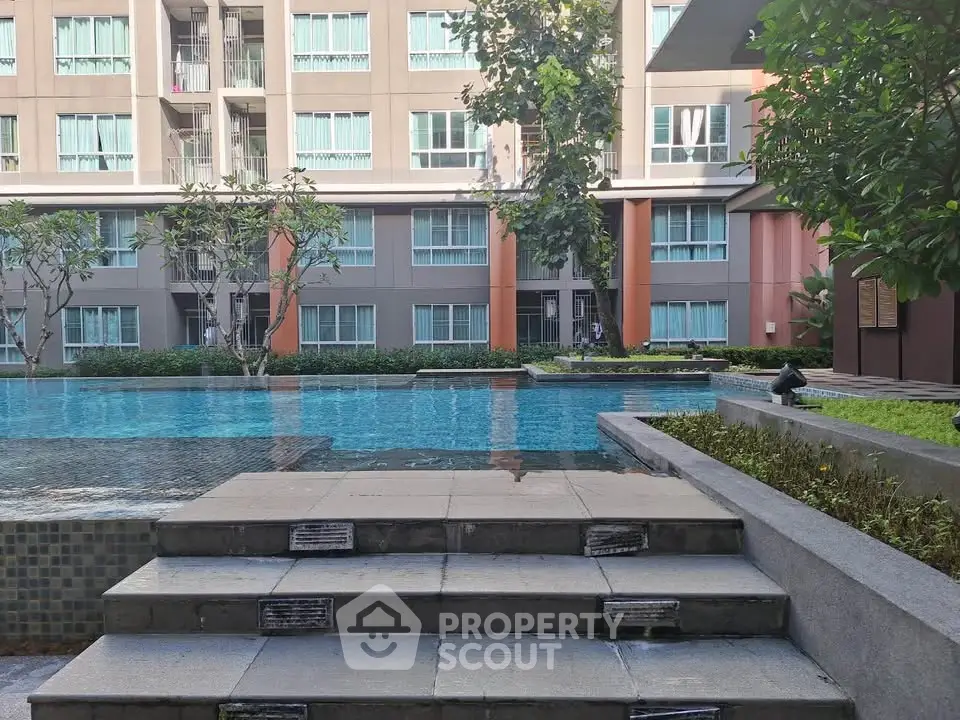 Luxurious apartment complex with serene pool and lush greenery, perfect for relaxation and modern living.