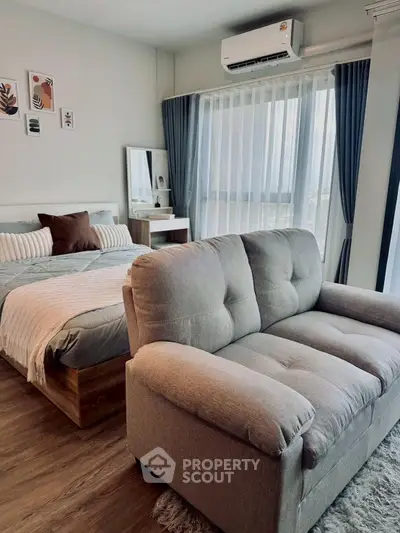Cozy studio apartment with modern decor, featuring a comfortable bed and sofa, perfect for urban living.