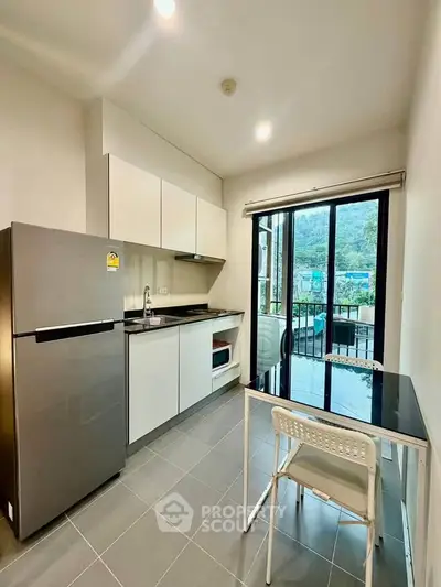 Modern kitchen with sleek appliances and mountain view from balcony.