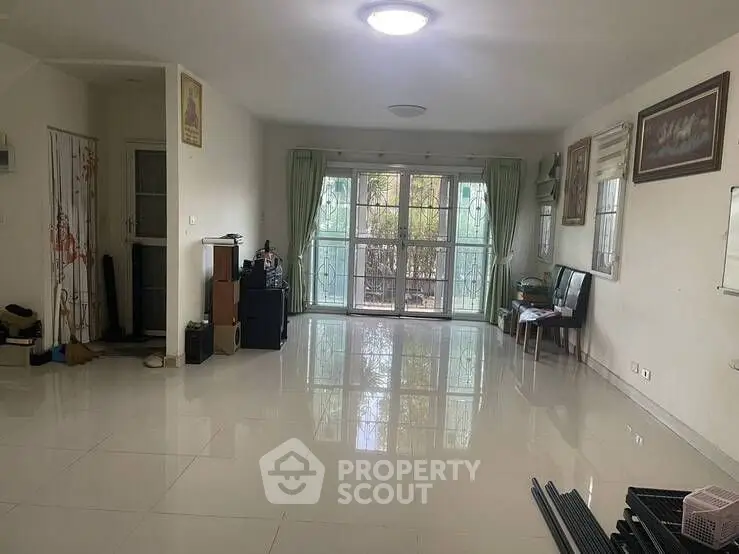 Spacious living room with large windows and glossy tiled floor