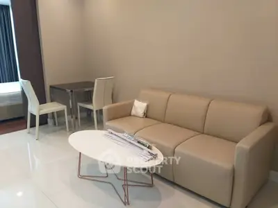 Modern living room with beige sofa and sleek coffee table in a stylish apartment.
