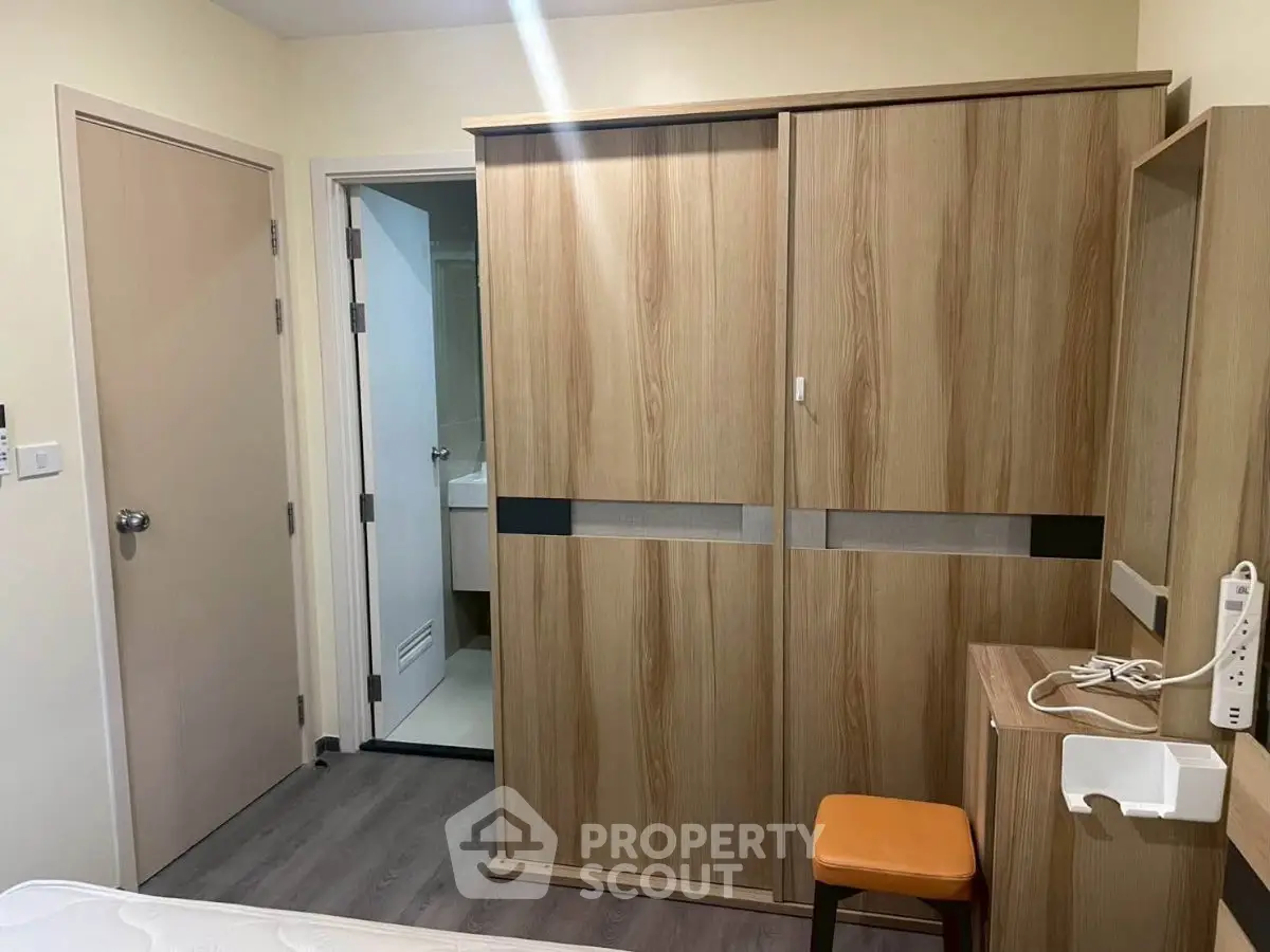 Cozy bedroom with wooden wardrobe and modern decor in a stylish apartment.