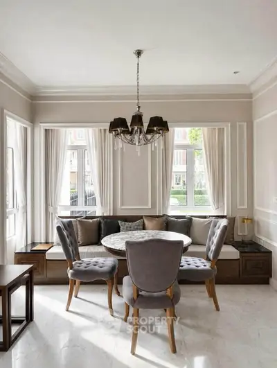 Elegant dining area with plush chairs and large windows in a modern home interior.