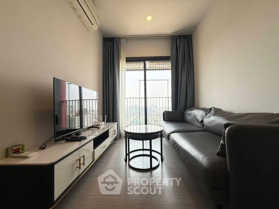 Modern living room with sleek furniture and city view balcony in high-rise apartment.