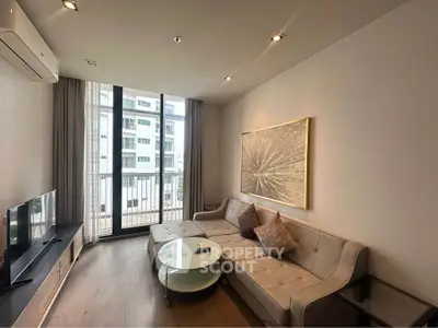 Modern living room with stylish furniture and large window offering natural light and city view.