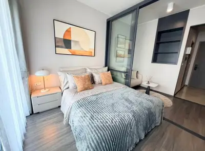 Modern bedroom with stylish decor and cozy ambiance, featuring a comfortable bed and elegant artwork.