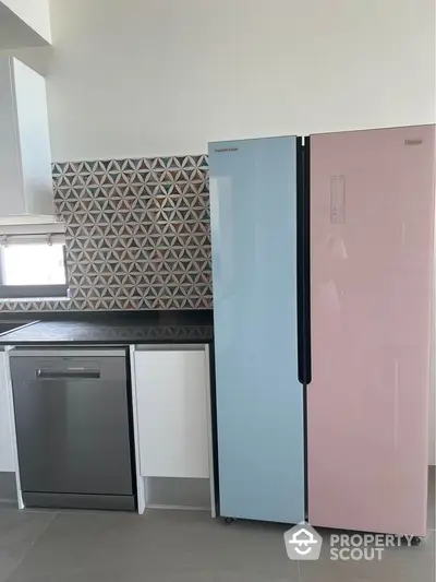 Modern kitchen with stylish pastel fridge and sleek dishwasher