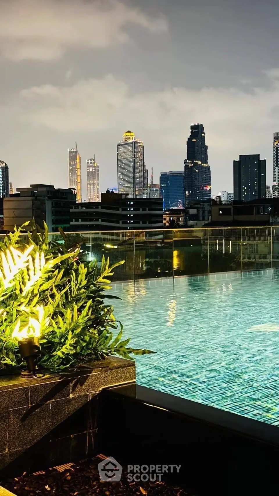 Luxurious rooftop pool with stunning city skyline view at night