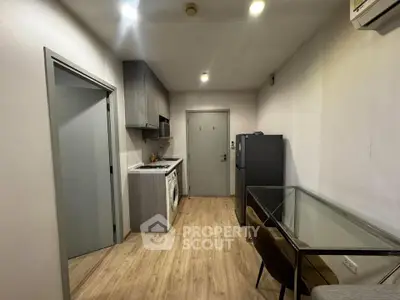 Modern apartment kitchen with sleek cabinetry and integrated appliances, featuring a compact dining area.