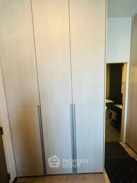 Modern storage area with sleek wooden cabinets and minimalist design.