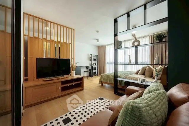 Modern open-plan living room and bedroom with stylish decor and natural light.