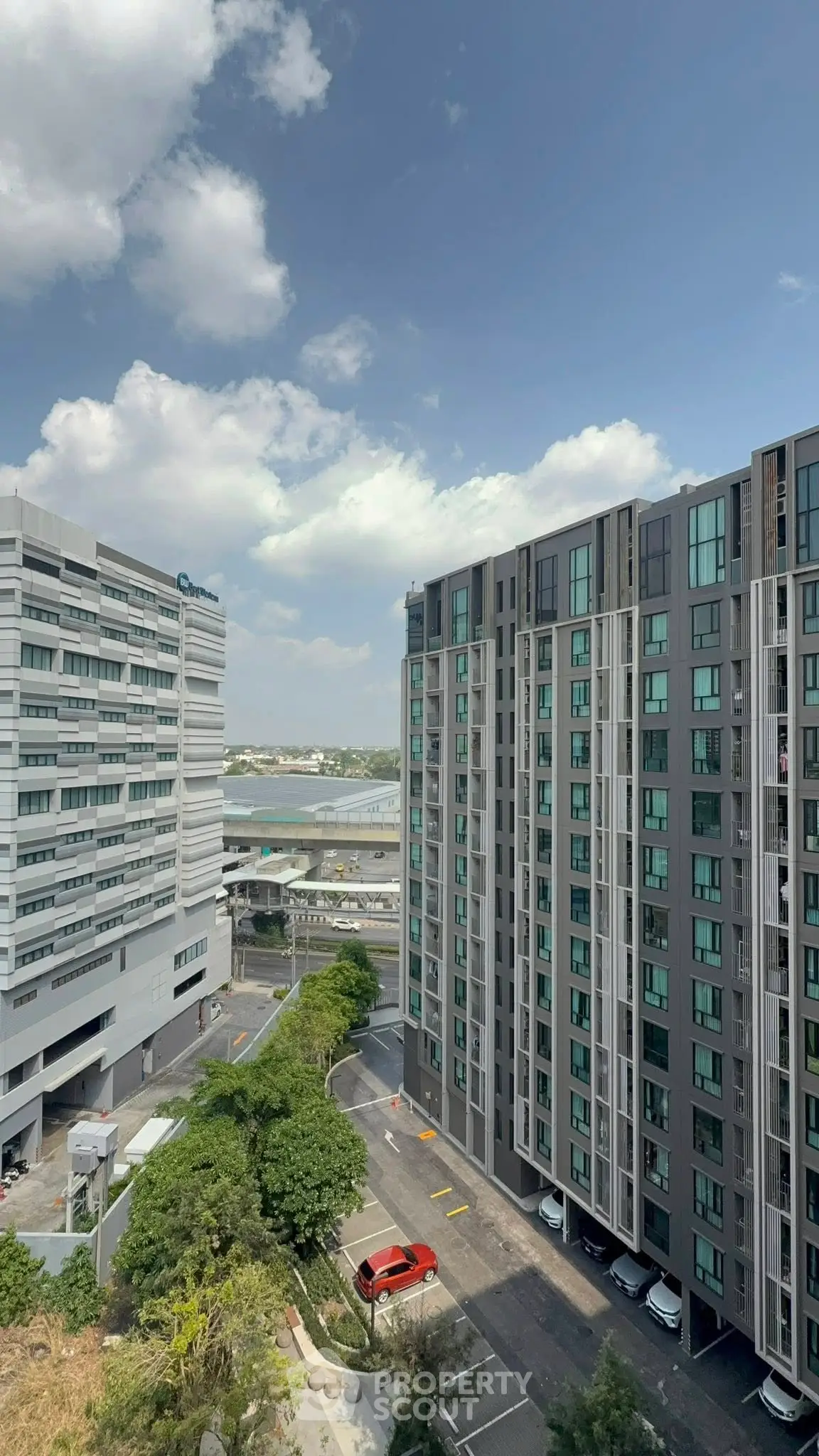 Modern high-rise apartment buildings with clear blue sky and urban surroundings.