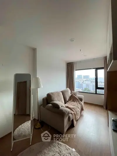 Cozy living room with plush sofa and city view, perfect for relaxation and comfort.