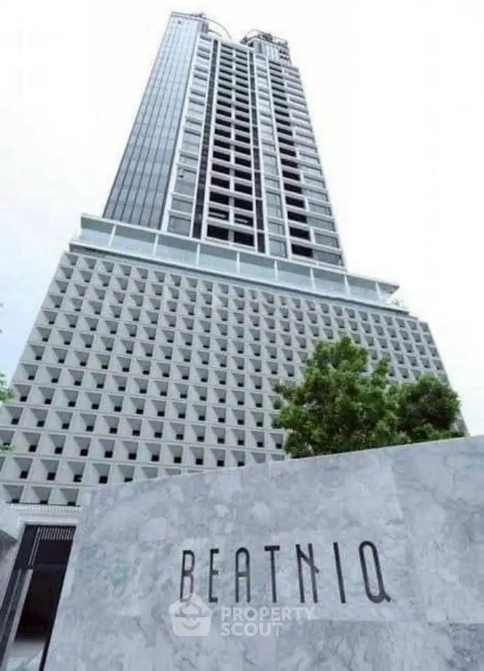 Modern high-rise building with unique architectural design and prominent signage.