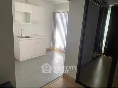 Modern minimalist kitchen with sleek white cabinetry and natural light.