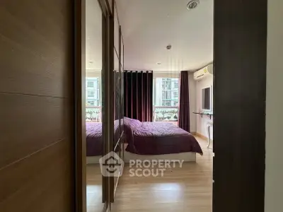 Spacious bedroom with modern decor and large window offering natural light.
