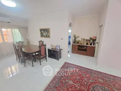 Spacious living room with elegant dining set and classic decor, featuring a large window for natural light.