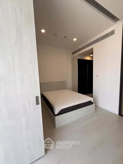 Modern minimalist bedroom with sleek design and ample natural light