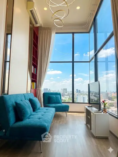 Modern living room with floor-to-ceiling windows and city view, featuring stylish blue sofas and elegant lighting.