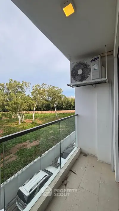 Charming balcony with glass railing and scenic view, perfect for relaxation and enjoying nature.