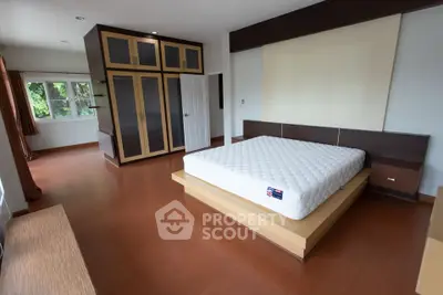 Spacious bedroom with modern design and large windows for natural light.