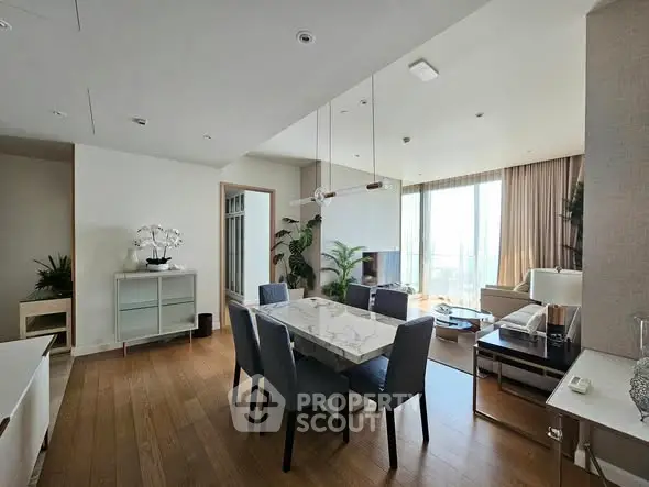 Spacious modern living room with dining area and large windows offering natural light.