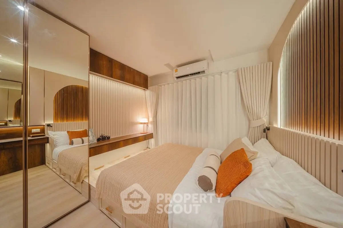 Luxurious bedroom with modern decor, mirrored wardrobe, and ambient lighting for a cozy atmosphere.