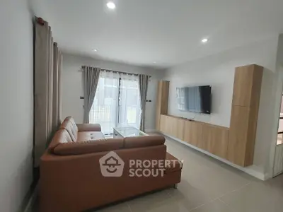Modern living room with sleek furniture and wall-mounted TV, featuring natural light and neutral tones.