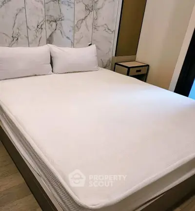 Luxurious bedroom with elegant marble accent wall and cozy bedding