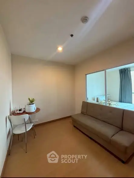 Cozy living room with modern sofa and dining set, perfect for small apartments.