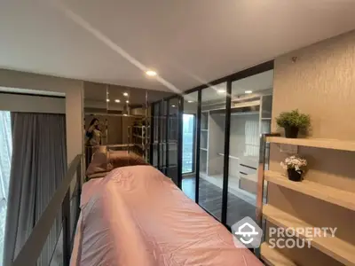 Modern bedroom with sleek design, featuring a large bed, mirrored wardrobe, and access to a private balcony with natural light.