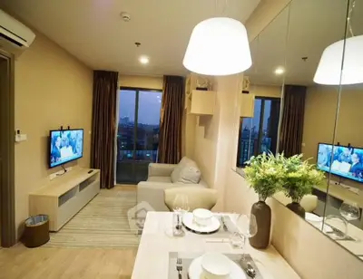 Modern living room with cozy sofa, dining area, and large window view.