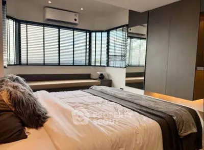 Luxurious bedroom with modern design and large windows for natural light.