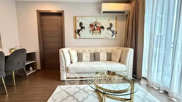 Luxurious living room with elegant decor and modern furniture, featuring a stylish sofa and chic glass coffee table.