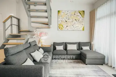 Modern living room with stylish gray sectional sofa and artistic wall decor