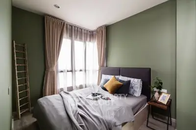 Cozy bedroom with modern decor and natural light, featuring a comfortable bed and stylish accents.