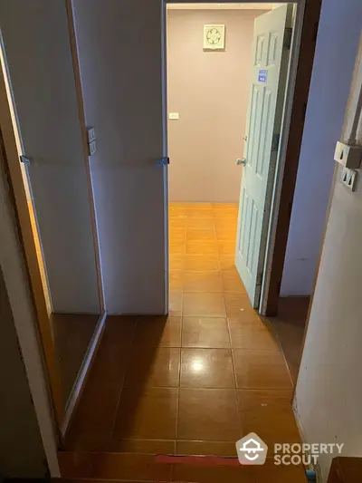 Cozy hallway with tiled flooring and mirrored closet doors in a residential property.