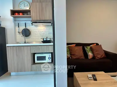 Modern studio apartment with compact kitchen and cozy living area, featuring stylish decor and efficient use of space.