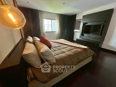 Luxurious bedroom with modern decor and large TV, perfect for relaxation.
