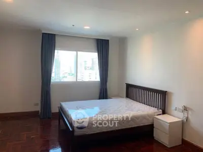 Spacious bedroom with city view, featuring a comfortable bed and elegant wooden flooring.