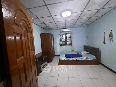 Spacious bedroom with tiled floor and wooden furniture, perfect for comfortable living.