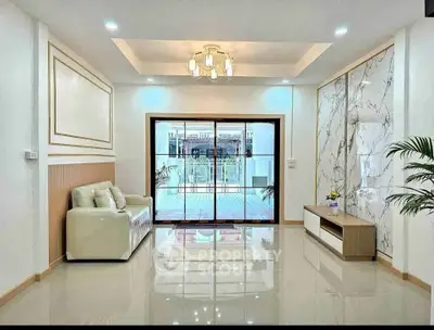 Elegant living room with modern decor and large glass doors opening to a balcony.