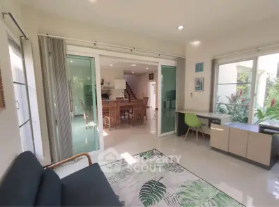 Spacious living room with open layout and garden view, featuring modern furniture and natural light.