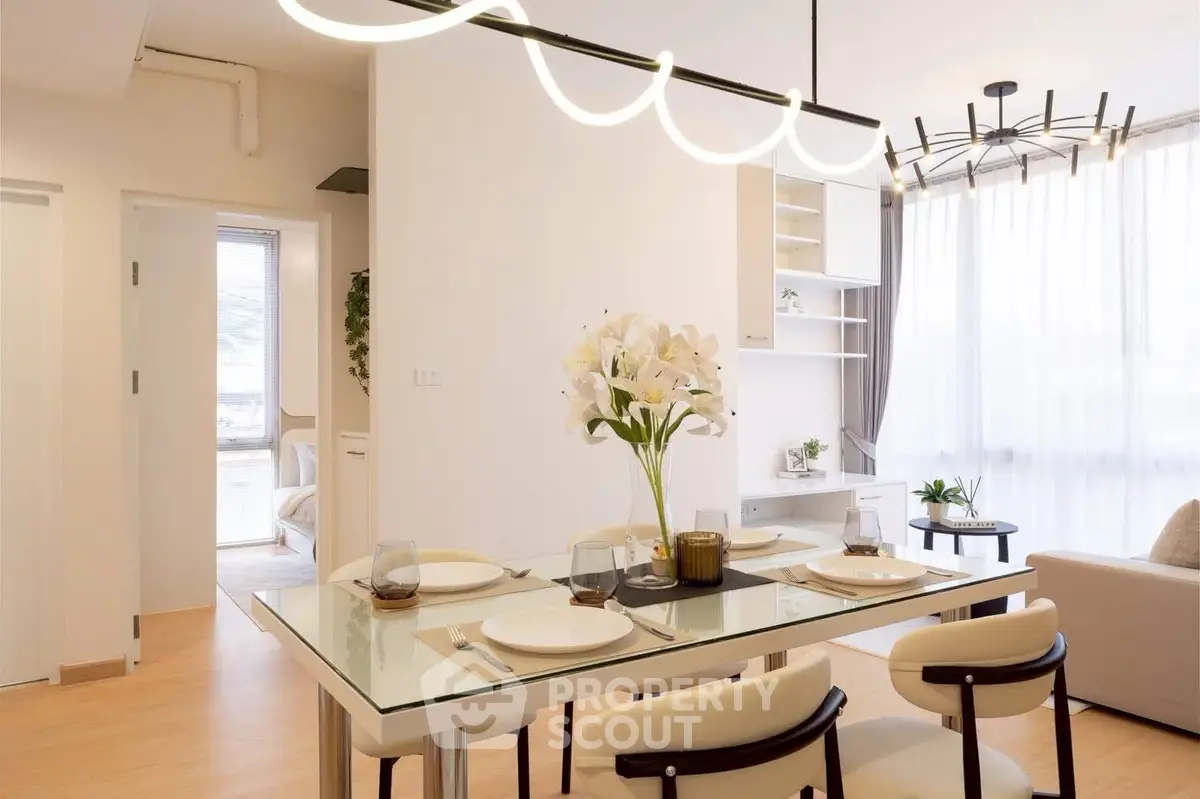 Elegant dining area with modern lighting and stylish decor in a bright apartment.