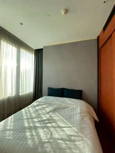 Cozy bedroom with natural light and modern decor, perfect for relaxation and comfort.