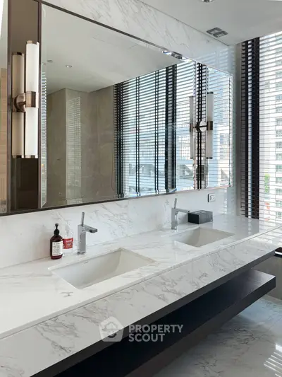 Luxurious modern bathroom with dual sinks and marble countertops in high-rise apartment.