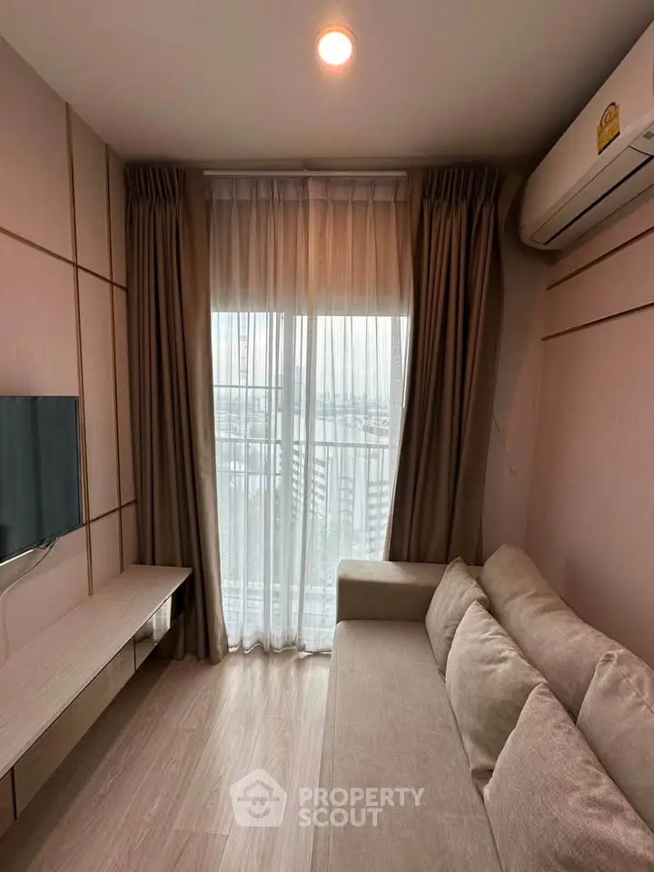 Cozy living room with modern sofa, wall-mounted TV, and large window with city view.
